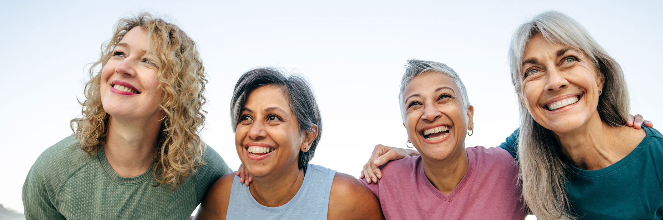 Group of women laughing arm in arm