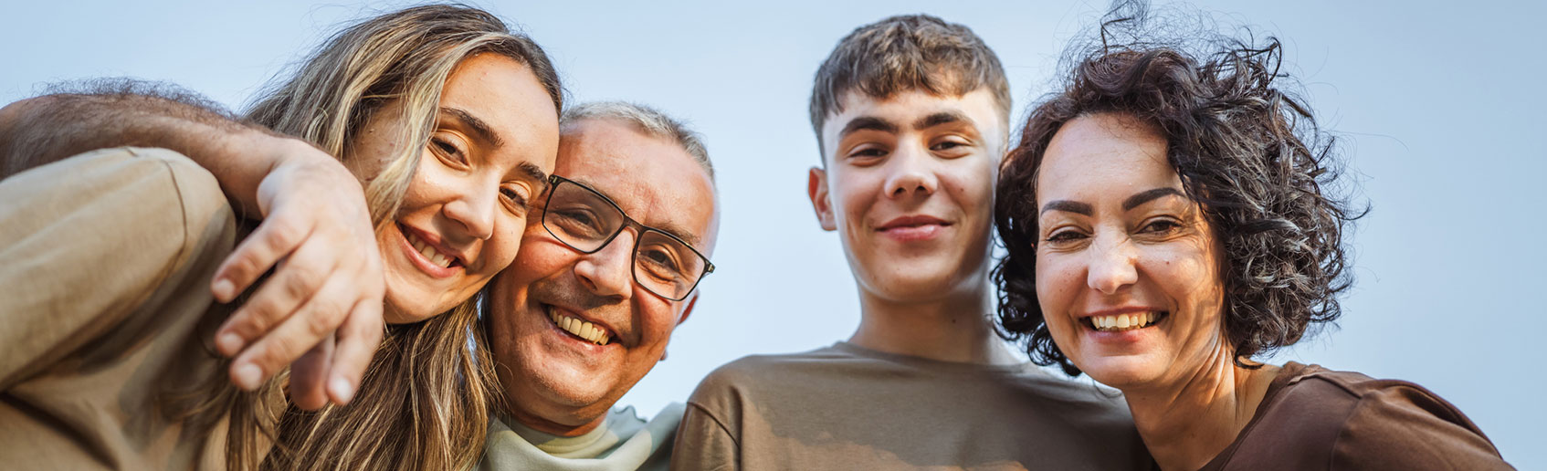 Smiling family locking arms together outdoors